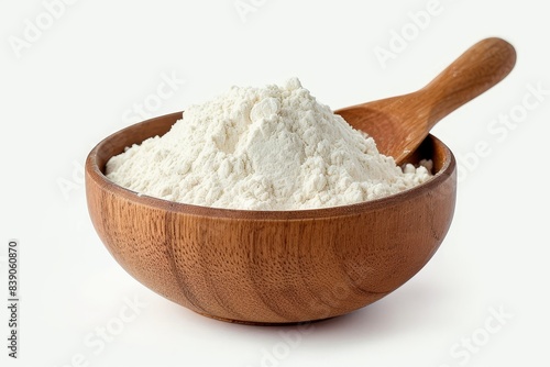 A flour spoon rests inside a wooden bowl filled with rice or wheat flour, which is seen on a plain white background, Generative AI