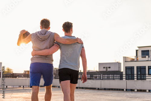 Friends playing basketball at sunset on a rooftop photo