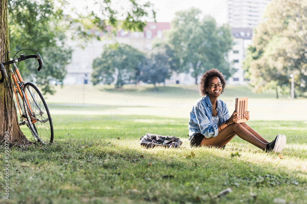 Smiling young woman resting in park with tablet Smiling young woman resting in park with tablet