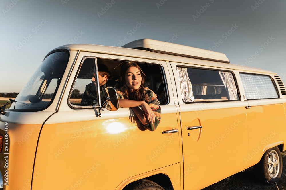 Happy couple sitting in their camper, watching the sunset