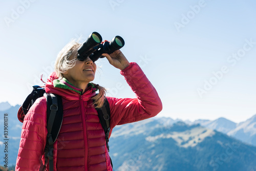 Austria, Tyrol, woman looking through binoculars during hiking trip