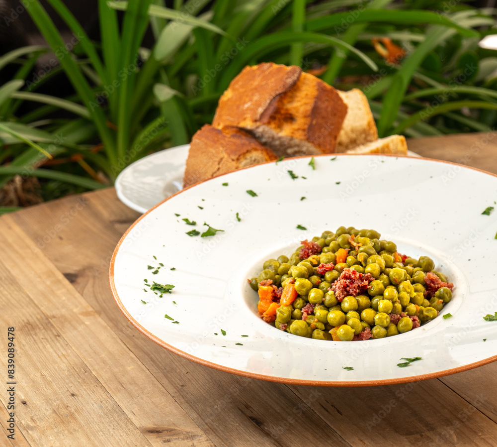 plato de guisantes con jamón y zanahoria al aire libre con pan y plantas en una mesa de madera plato de guisantes con jamón y zanahoria al aire libre con pan y plantas en una mesa de madera
