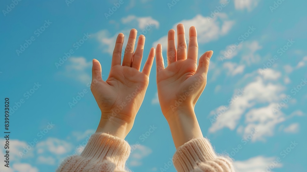 Two hands reaching up towards the sky, with a blue sky in the background Two hands reaching up towards the sky, with a blue sky in the background
