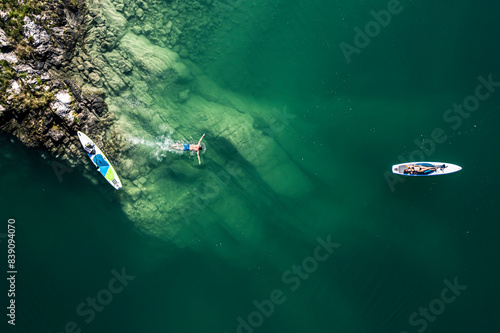 Germany, Bavaria, Aerial view of twopaddleboardersrelaxing on green shore of LakeWalchen photo