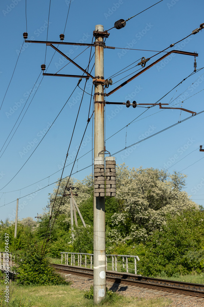 Obraz premium A pole with power wires near the railway track