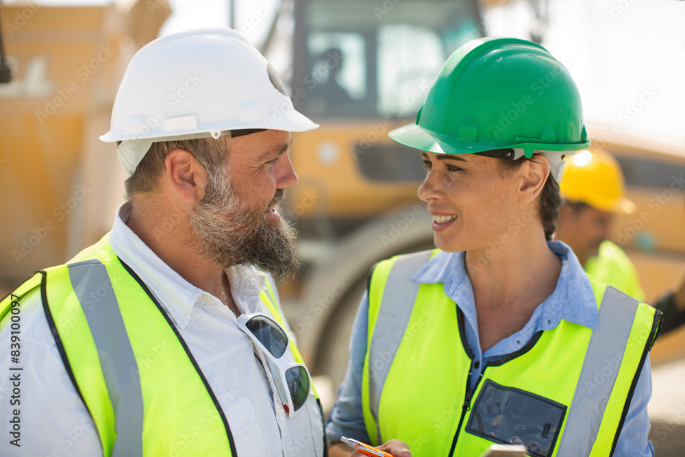 Male and female quarry workers discussing on site Male and female quarry workers discussing on site
