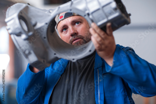 Car mechanic holding car transmission housing