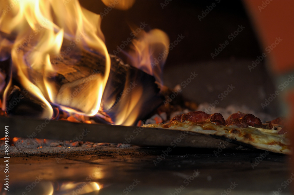 Close-up of delicious pizza being cooked in a burning oven Close-up of delicious pizza being cooked in a burning oven