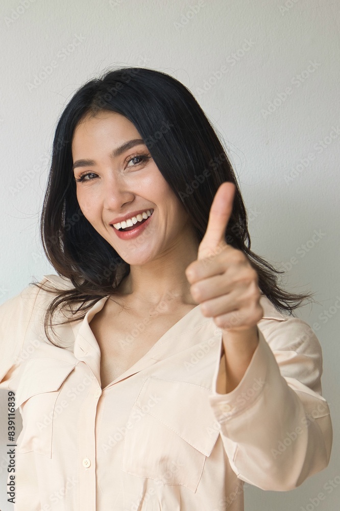 Asian Woman giving approving thumb up for yes, alright, ok, positive, OK for all correct gesture Asian Woman giving approving thumb up for yes, alright, ok, positive, OK for all correct gesture