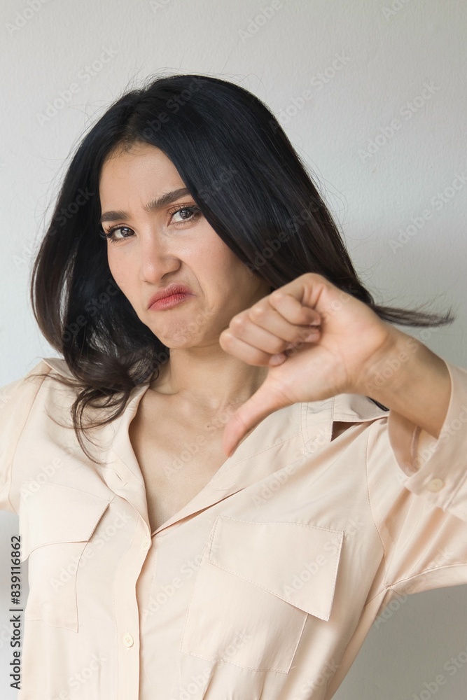 Angry Asian Indian Woman Expressing Disagreement with thumb down hand Gesture, concept image of Wrong, Rejection, no way, bad, deny, refuse, disagree, dislike, Unhappy and Negative expression Angry Asian Indian Woman Expressing Disagreement with thumb down hand Gesture, concept image of Wrong, Rejection, no way, bad, deny, refuse, disagree, dislike, Unhappy and Negative expression