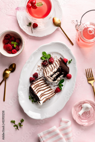 Pancake chocolate cake with fresh raspberries on a pink background.