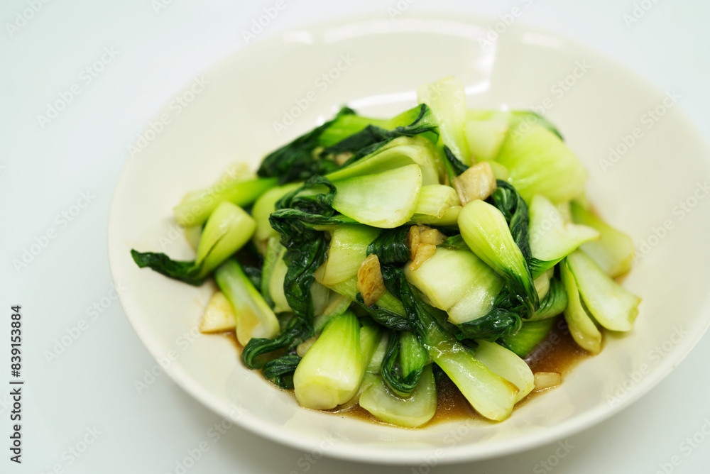 Healthy and delicious menu, stir fried vegetables or Bok Choy with garlic and oyster sauce on white background. Close up the food. Healthy and delicious menu, stir fried vegetables or Bok Choy with garlic and oyster sauce on white background. Close up the food.
