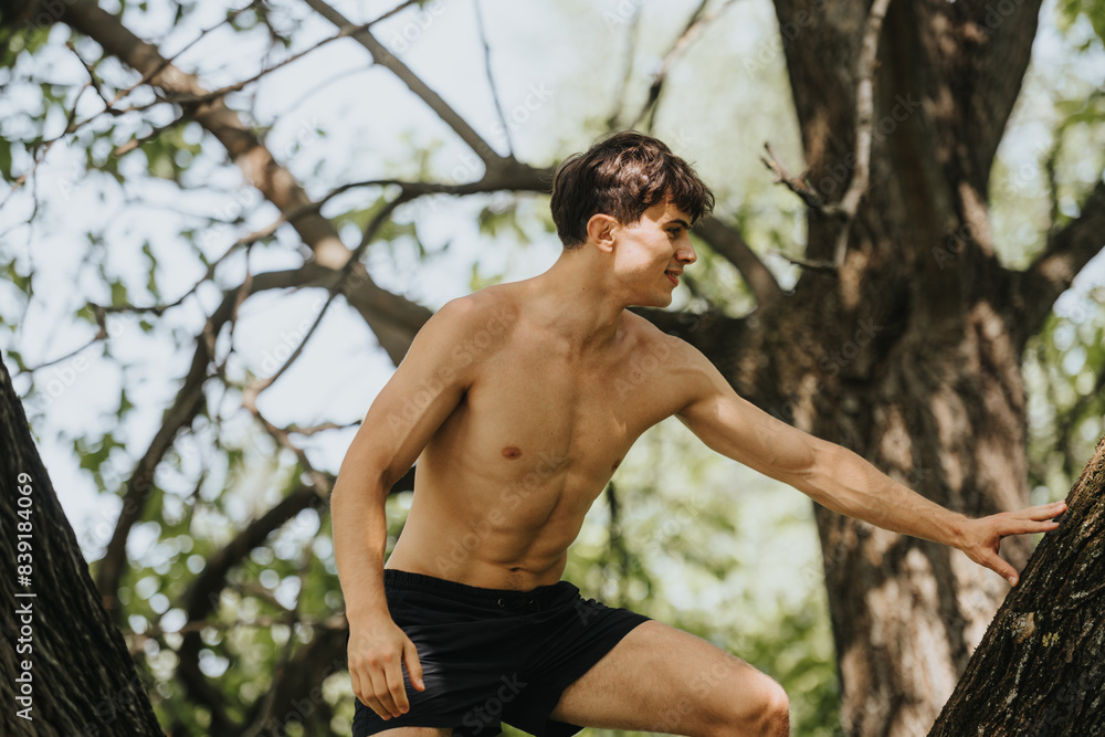 Athletic young man climbs a tree in a natural, outdoor setting, showcasing fitness and adventurous spirit. Athletic young man climbs a tree in a natural, outdoor setting, showcasing fitness and adventurous spirit.