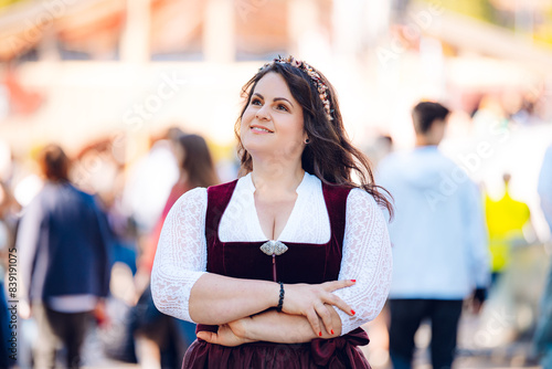 Canvas Print Young, beautiful woman in a traditional Oktoberfest dirndl walks across the Wies