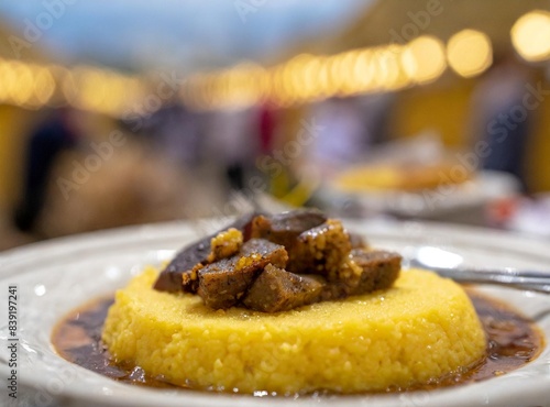 Polenta with Ragu at a gastronomic festival in Sicily, with traditional food tents. Sicilian Traditional Food.