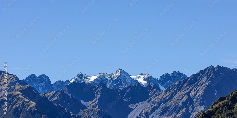 Panoramic view of a mountain range, close-up on layered peaks under a clear blue sky, vibrant daylight. Panoramic view of a mountain range, close-up on layered peaks under a clear blue sky, vibrant daylight.