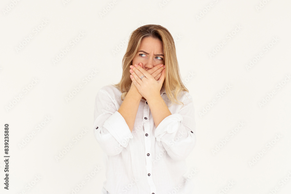 Shocked confused woman covering her mouth with hands isolated on white background Shocked confused woman covering her mouth with hands isolated on white background