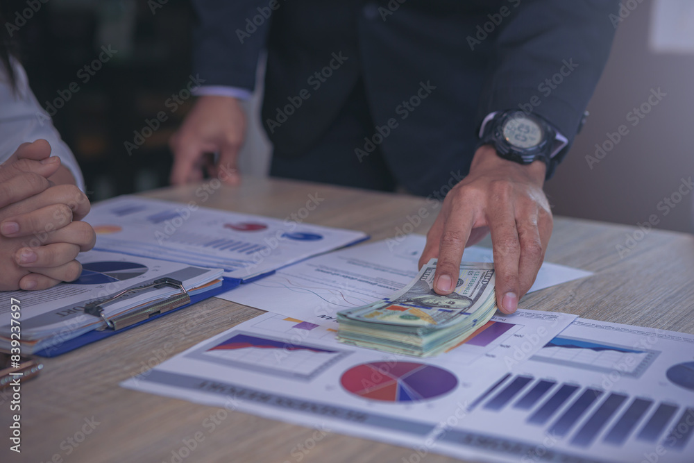 Businessman paid Dollars money banknotes and making decision for business investment. Selected focus Businessman paid Dollars money banknotes and making decision for business investment. Selected focus