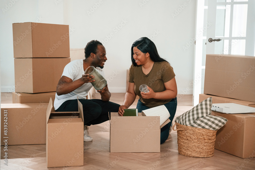 Glass furniture in hands. African American couple are moving into new house Glass furniture in hands. African American couple are moving into new house