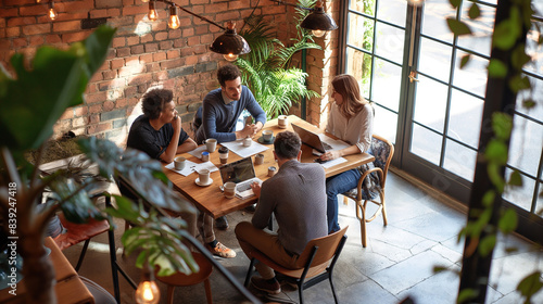 Colleagues having a morning coffee meeting at a stylish cafÃ©, discussing business ideas and strategies in a relaxed setting.