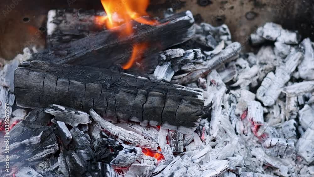 burning fire in old traditional oven.firewoods, tree branches under big cauldron with black coal on surface.boiling water flows over cover. preparing food outside, flame and smoke. burning fire in old traditional oven.firewoods, tree branches under big cauldron with black coal on surface.boiling water flows over cover. preparing food outside, flame and smoke.