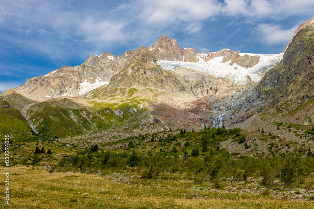 Obraz premium Tour du Montblanc beautiful mountain ladscapes of the Alps green valley, snow summit of Montblanc and rocky peaks of Aiguille du Midi in summer sunny weather blue sky, trekking and hiking in Chamonix
