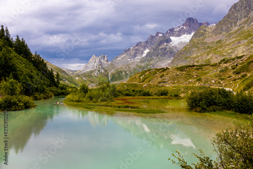 Tour du Montblanc beautiful mountain ladscapes of the Alps green valley, snow summit of Montblanc and rocky peaks of Aiguille du Midi in summer sunny weather blue sky, trekking and hiking in Chamonix