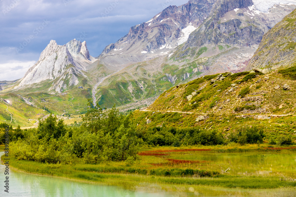 Obraz premium Tour du Montblanc beautiful mountain ladscapes of the Alps green valley, snow summit of Montblanc and rocky peaks of Aiguille du Midi in summer sunny weather blue sky, trekking and hiking in Chamonix