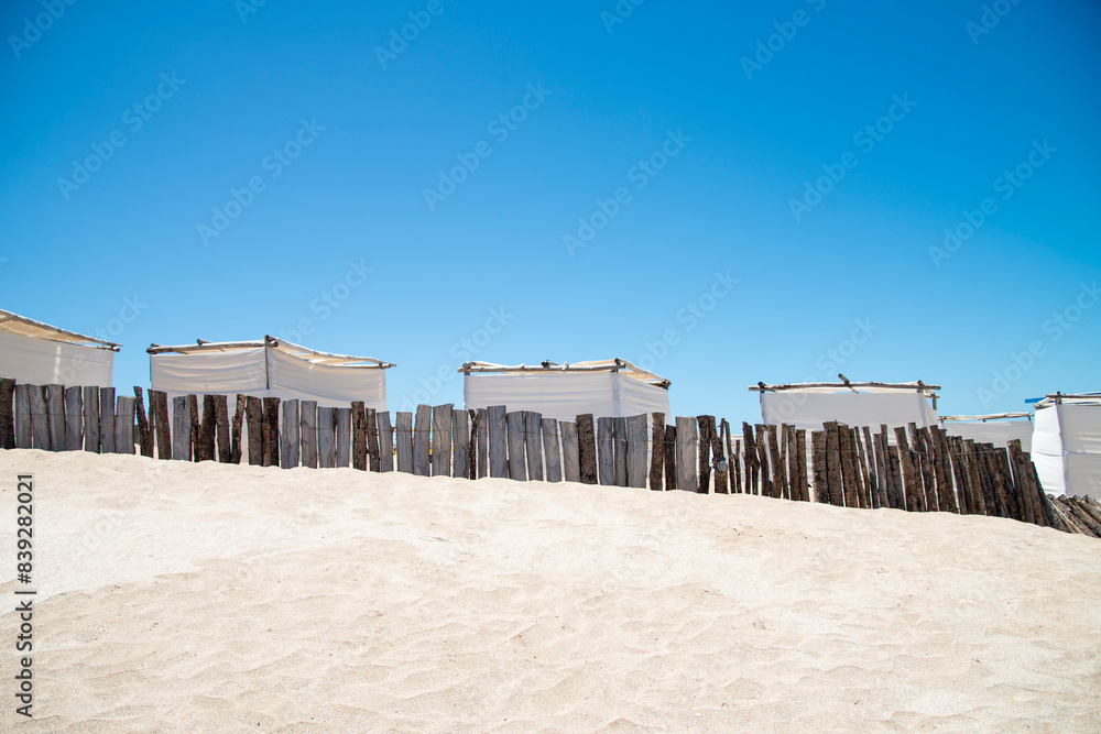 White tents on the sand of a deserted beach White tents on the sand of a deserted beach