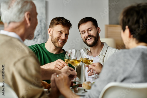 A gay couple raises a glass with parents during a celebratory dinner at home.