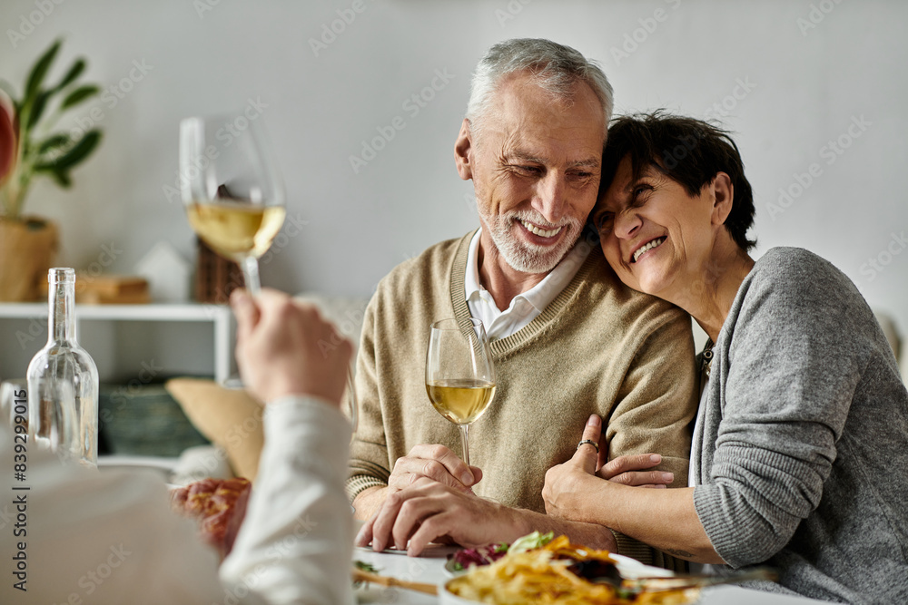 Parents share meal with their son and his partner at a cozy dinner at home. Parents share meal with their son and his partner at a cozy dinner at home.