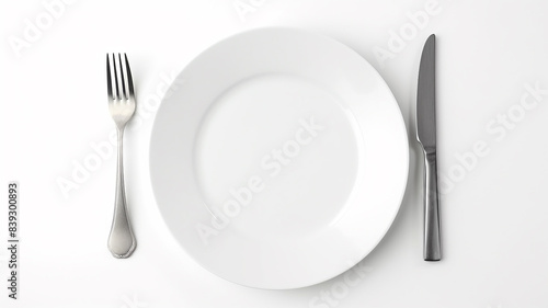 A white empty round plate on a white background with a knife and fork  an image of a table setting with copy space