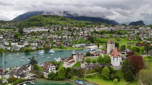 by Spiez Castle ( by Lake Thun (Thunersee), a lake in the Bernese Alps, Spiez Marina , Castle Church in Spiez , Panoramic Train Route (Panorama Express) drone, aerial