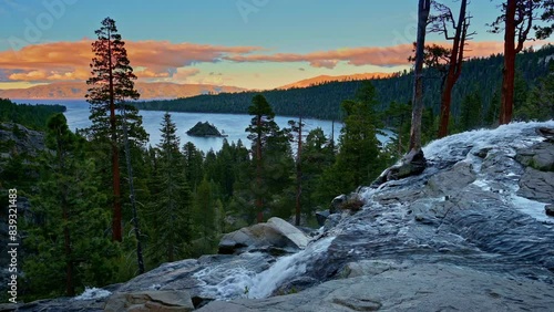Sunset view of Lower Eagle Falls flowing into Emerald Bay surrounded by pine trees and distant Sierra Nevada mountains at Lake Tahoe, California. 4K UHD video.