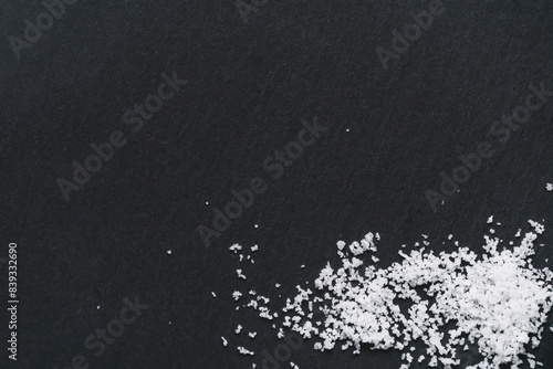 Organic sea white salt on a black slate background. Concept of cooking natural healthy food