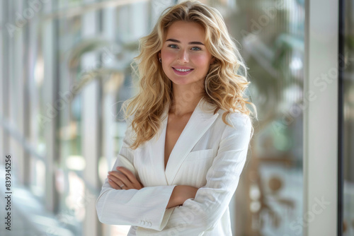 Blonde businesswoman in white formal suit dress arms crossed in modern office Free Download Blonde businesswoman in white formal suit dress arms crossed in modern office - GFXLoad