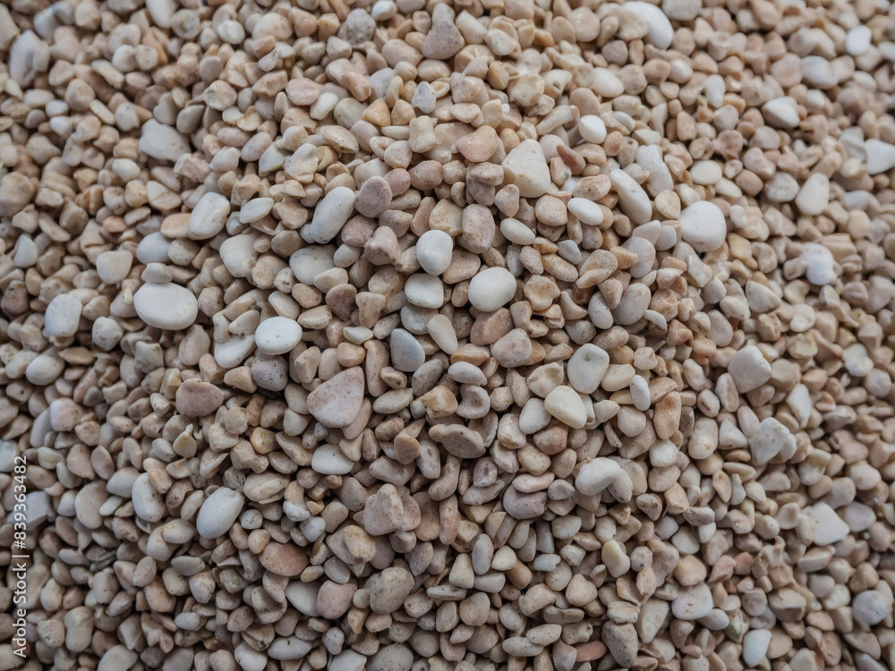 Gravel aggregate arranged to create a white background with a textured surface. Gravel aggregate arranged to create a white background with a textured surface.