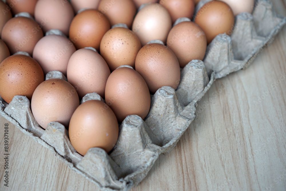 Chicken eggs in egg cartons on a wooden table Chicken eggs in egg cartons on a wooden table