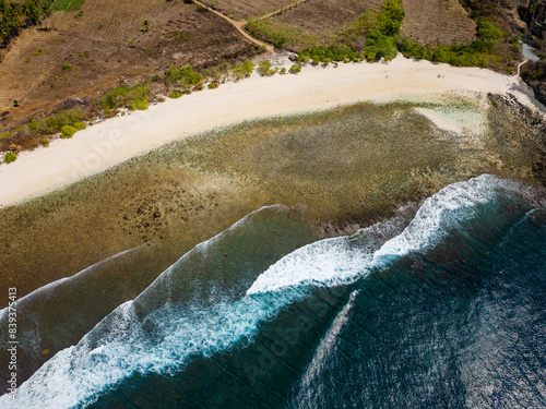 Top-down aerial view of a quiet tropical beach with breaking waves and coral reef (Mawi Beach, Lombok) photo