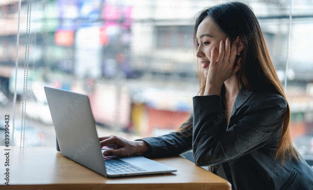 Smiling young asian businesswoman using computer at home office workplace, happy korean employee working on laptop, attractive japanese or chinese woman student studying communicating online with pc Smiling young asian businesswoman using computer at home office workplace, happy korean employee working on laptop, attractive japanese or chinese woman student studying communicating online with pc