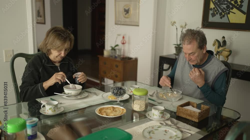 Breakfast Time for Elderly Couple at Stylish Dining Table with Modern Rustic Charm, Background Adorned with Wall Art and Elegant Furnishings Breakfast Time for Elderly Couple at Stylish Dining Table with Modern Rustic Charm, Background Adorned with Wall Art and Elegant Furnishings