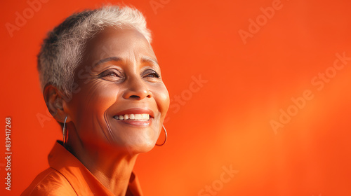 Elegant, elderly pensioner, chic African American woman with gray short hair, orange background, banner.