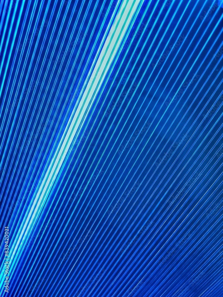 Obraz premium Bright intersecting rays of light of different colors. Fractal image of blue concentric ripples for a background. Directional motion blurred background or backdrop. Metal sheet background