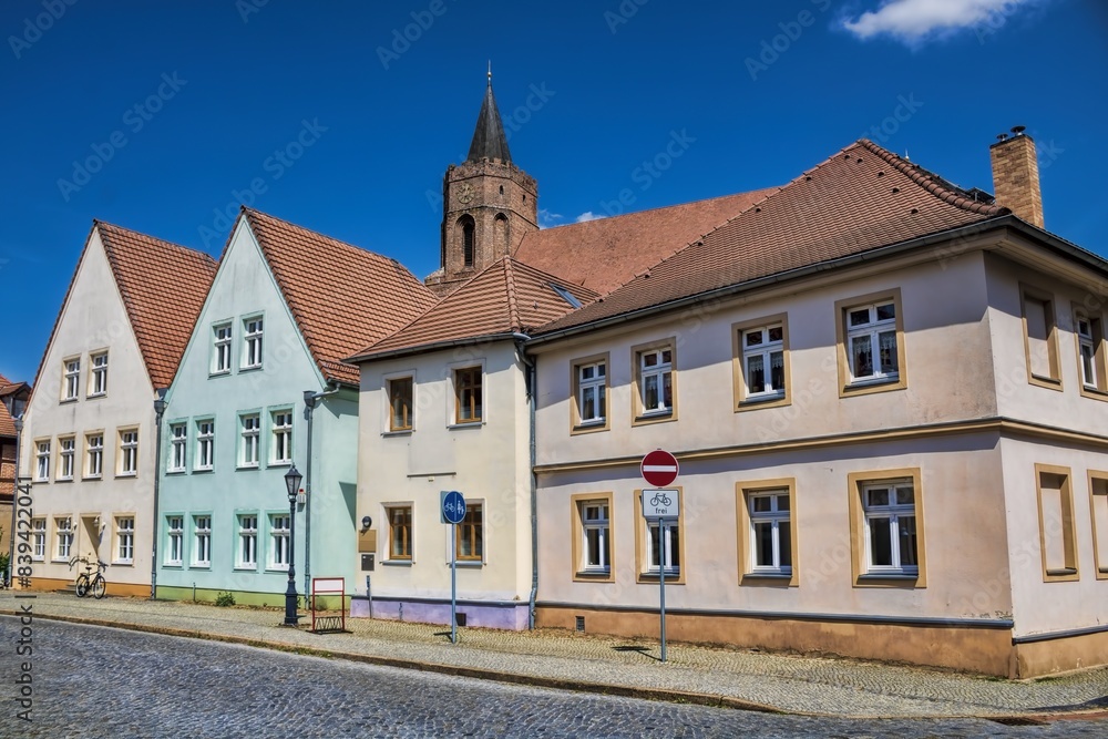 beeskow, deutschland - sanierte häuserzeile und turm der marienkirche
