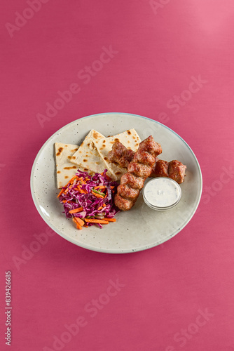 Delicious Chicken Lyulya Kebab with Lavash and Coleslaw on a Colorful Background photo