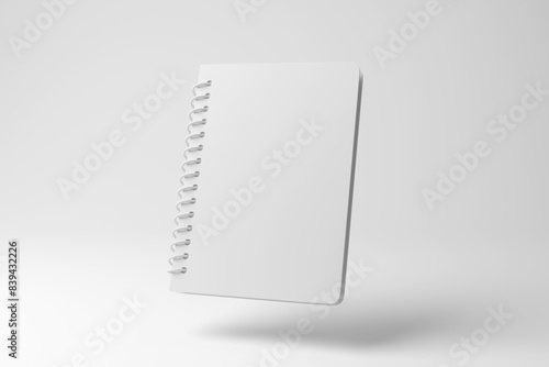 White spiral lined notebook floating in mid air on white background in monochrome and minimalism. Illustration of the concept of education, office stationary and note taking