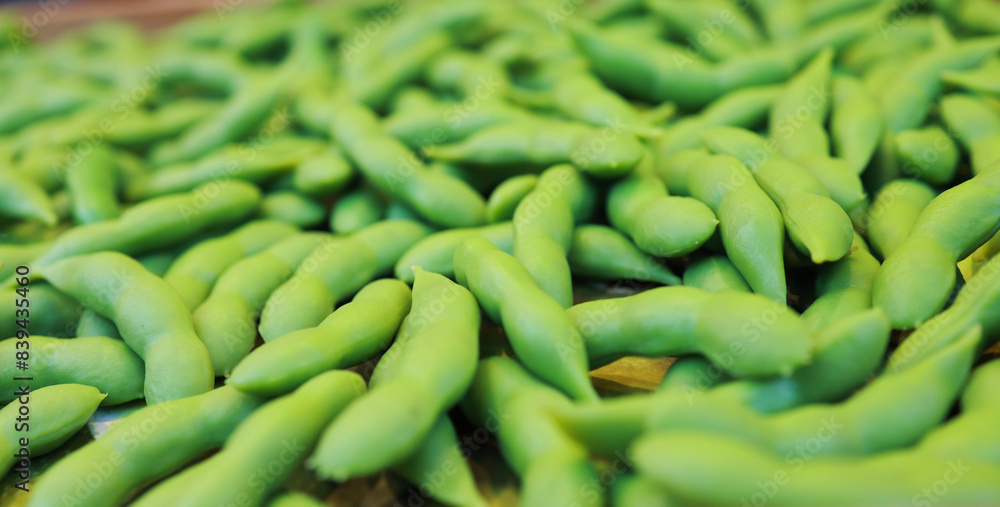 Many green edamame beans in pods as background, closeup,boiled green soybeans, Japanese beans Many green edamame beans in pods as background, closeup,boiled green soybeans, Japanese beans