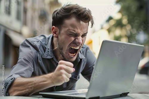 a man angry at a laptop screen, rage , frustrated , stress, mad , furious

