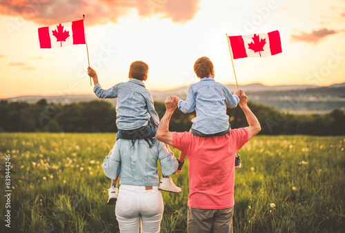 Quadro su tela Adorable cute family holding Canadian flag on the shoulder