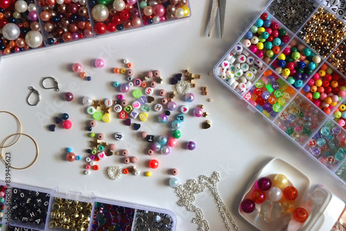 Foto Colorful beads, letter beads, threads and other jewelry making supplies on white background